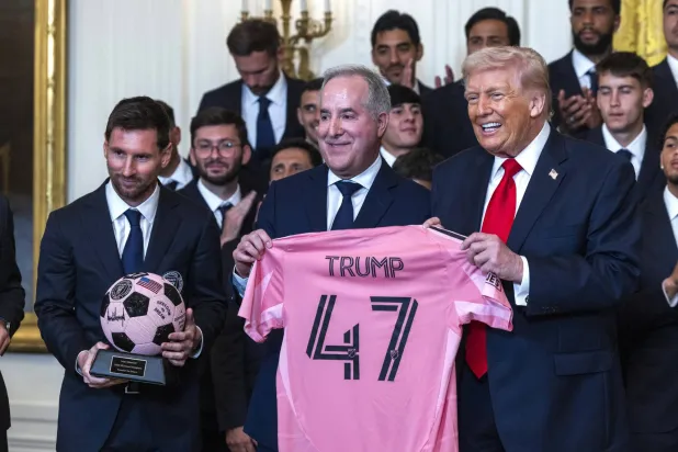 ليونيل ميسي ومالك الفريق خورخي ماس يقدمان هدية للرئيس الأميركي دونالد ترمب (إ.ب.أ)