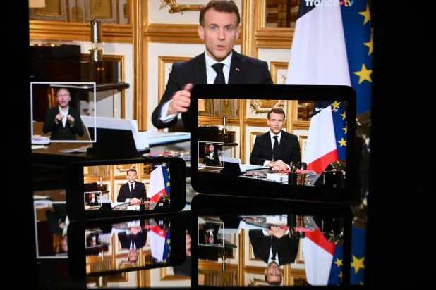 This photograph shows screens broadcasting French President Emmanuel Macron's address on the war in Iran and its repercussions in the Middle East, from the Elysee Palace in Paris on March 3, 2026. (Photo by SEBASTIEN BOZON / AFP)
