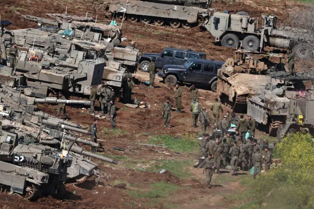 جنود إسرائيليون يقفون إلى جانب دباباتهم في موقع عسكري على الحدود الإسرائيلية اللبنانية (إ.ب.أ)