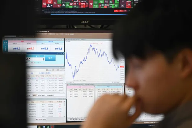 تاجر عملات يراقب أسعار الصرف في غرفة تداول العملات الأجنبية بمقر بنك هانا في سيول (أ.ف.ب)