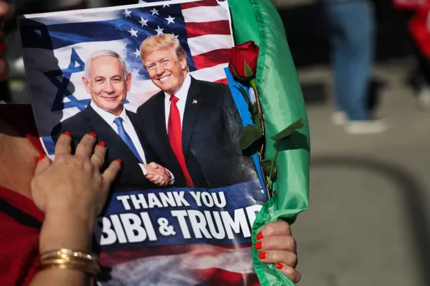 A person holds a sign supporting Israeli Prime Minister Benjamin Netanyahu and US President Donald Trump during a gathering of Iranian community members showing support for Israel and the United States, outside the Consulate General of Israel in Los Angeles, on March 5, 2026. (AFP)