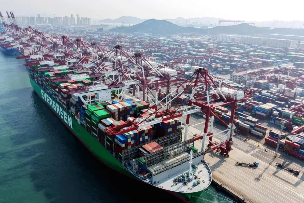 سفينة شحن وحاويات في ميناء بمدينة تشينغداو في مقاطعة شاندونغ بشرق الصين (أ.ف.ب)