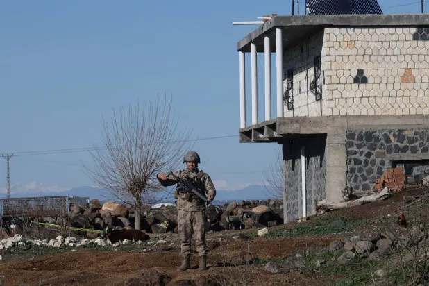A Turkish soldier stands guard as army and security personnel search a field after a piece of ammunition fell following the interception of a missile launched from Iran by a NATO air defense system, in Diyarbakir, Türkiye, March 9, 2026. REUTERS/Sertac Kayar