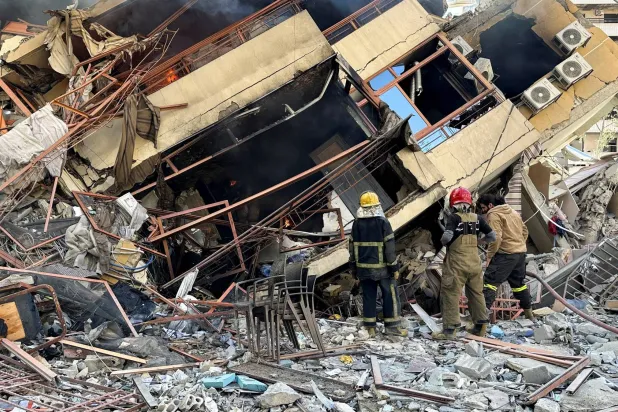 يتفقد عناصر من «الدفاع المدني» اللبناني مبنىً مهدماً بعد غارة إسرائيلية على الضاحية الجنوبية لبيروت (رويترز)