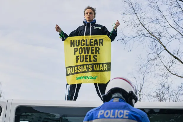 ناشط من منظمة «غرينبيس» يحمل لافتة على سطح شاحنة خلال احتجاج خارج قمة الطاقة النووية التابعة للوكالة الدولية للطاقة الذرية في باريس (أ.ب)