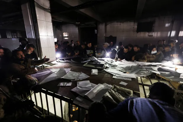 سوريون يبحثون عن ذويهم بين كشوف المعتقلين في سجن بدمشق (رويترز)