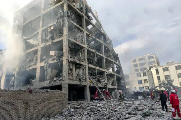 أعضاء من فرق «الهلال الأحمر» الإيراني يوم الثلاثاء في موقع مبنى تضرر بغارة جوية أميركية - إسرائيلية في طهران (د.ب.أ)