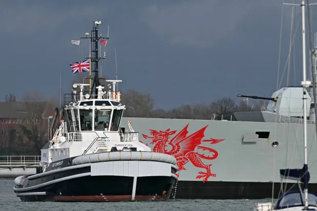 قاطرة «SD Tempest» البريطانية بجانب سفينة «HMS Dragon» وهي مدمرة دفاع جوي تابعة للبحرية الملكية البريطانية في قاعدة بورتسموث البحرية الملكية على الساحل الجنوبي لإنجلترا 10 مارس 2026 (أ.ف.ب)