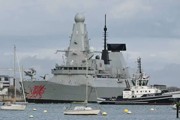 سفينة «إتش إم إس دراغون» وهي مدمرة تابعة للبحرية الملكية البريطانية يتم توجيهها بواسطة قوارب القطر في أثناء مغادرتها قاعدة بورتسموث البحرية الملكية على الساحل الجنوبي لإنجلترا 10 مارس 2026 (أ.ف.ب)
