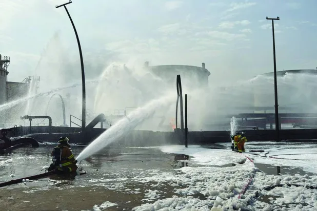 
رجال الإطفاء في البحرين يخمدون حريقاً تسببت به هجمات إيرانية (أ.ب)