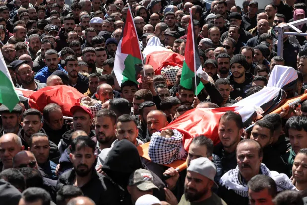 Mourners carry the bodies of three Palestinians killed in a reported attack by Israeli settlers in the town of Abu Falah, northeast of Ramallah in the occupied West Bank, during the funeral on March 8, 2026. (Photo by Zain JAAFAR / AFP)
