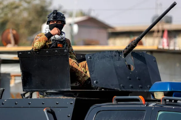 أحد أفراد قوات الأمن العراقية يُشرف على برج دفاعي خلال حراسته جنازة أحد عناصر «الحشد الشعبي» العراقي في بغداد (أ.ف.ب)