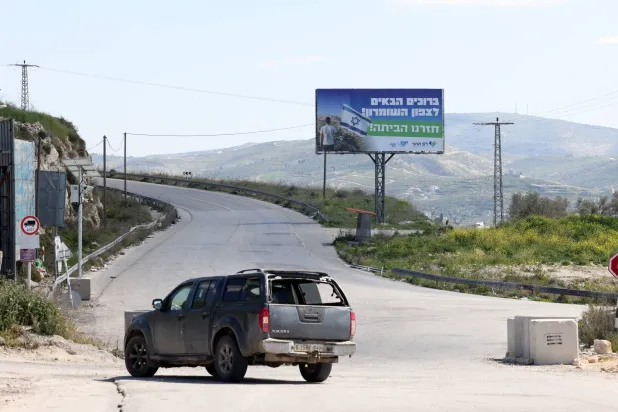 لافتة وضعها مستوطنون إسرائيليون على جانب طريق قرب مدينة نابلس ترحب بالمستوطنين باعتبار المنطقة ديارهم (إ.ب.أ)