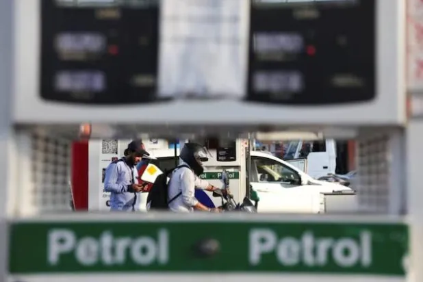 مواطن يغادر بعد تزويد دراجته بالوقود في محطة وقود بنيودلهي (رويترز)