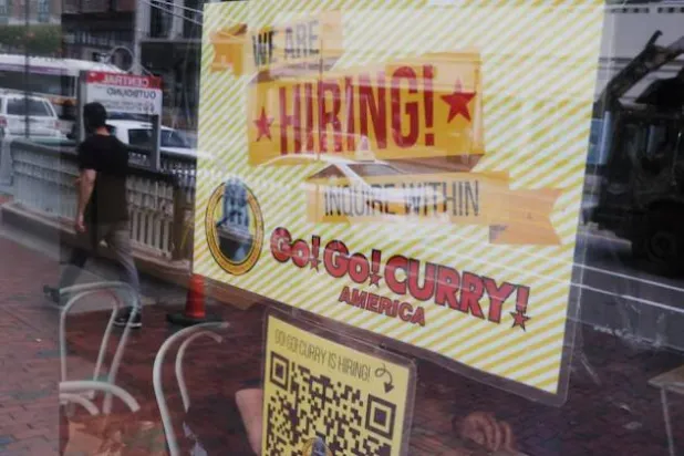 مطعم يعرض لافتة على نافذته كتب عليها «نحن نوظف» في كامبريدج (رويترز)