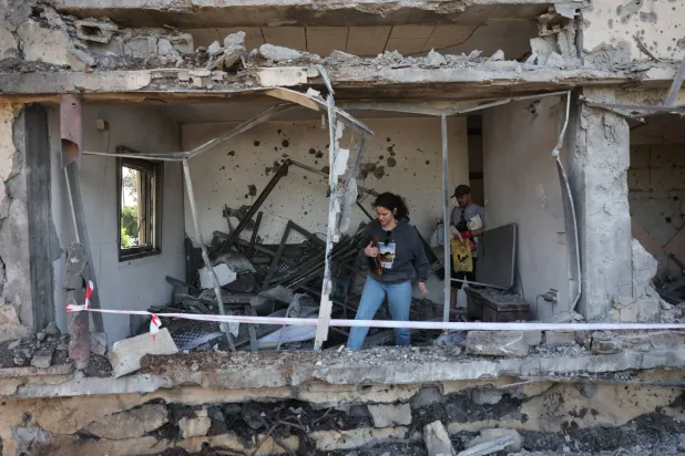 سكان يتفقدون أضراراً بعد أن أصاب صاروخ أطلقه «حزب الله» من لبنان منزلاً بالقرب من مدينة نتانيا إسرائيل 12 مارس 2026 (إ.ب.أ)
