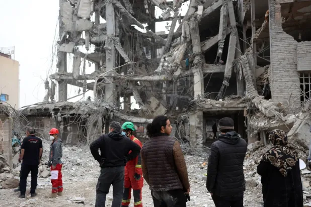 İranlılar dün Tahran'ın merkezinde ABD-İsrail bombardımanı sonucu hasar gören konut binalarını inceliyor (EPA)