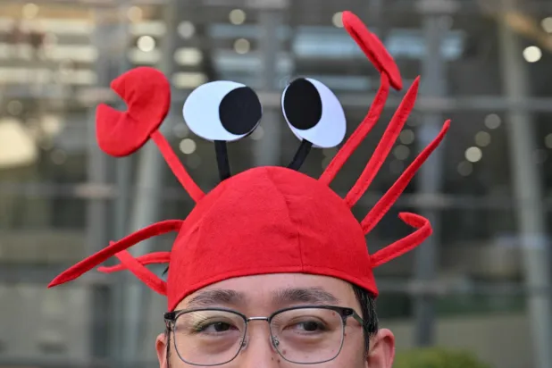 A man wears a lobster hat that represents the OpenClaw logo, an open-source AI assistant at the Baidu headquarters in Beijing on March 11, 2026. (Photo by ADEK BERRY / AFP)