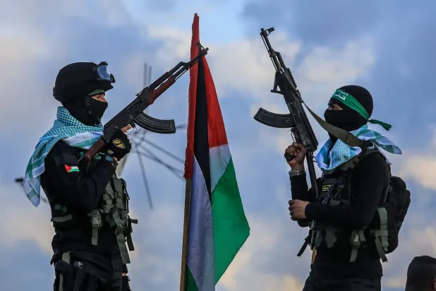 Hamas'ın Han Yunus bölgesinde iki Hamas militanı, hareketin dört İsrailli rehinenin cesetlerini Kızılhaç'a teslim ettiği yeri koruyor (DPA)