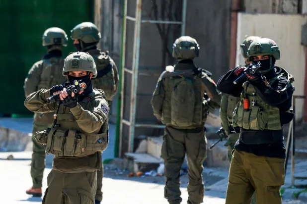 TOPSHOT - Israeli soldiers patrol a street during a military operation in the Askar refugee camp in eastern Nablus, Israeli-occupied West Bank, on March 2, 2026. (Photo by Jaafar ASHTIYEH / AFP)