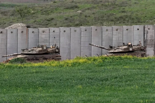 Two Israeli tanks deployed along the border barrier with Lebanon during fighting with Hezbollah (EPA). 