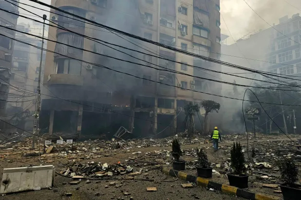 وصل أحد رجال الإنقاذ إلى موقع غارة جوية إسرائيلية استهدفت مجمعاً سكنياً في ضاحية حارة حريك جنوب بيروت (أ.ف.ب)