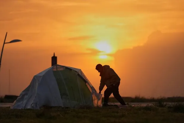  A man secures a tent at sunset at a public space where people displaced by Israeli airstrikes have set up tents along the Beirut waterfront in Beirut, Lebanon, Sunday, March 15, 2026. (AP) 