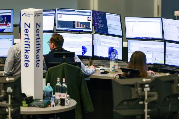 متداولون يراقبون شاشات الأسهم في قاعة التداول ببورصة فرنكفورت (إ.ب.أ)