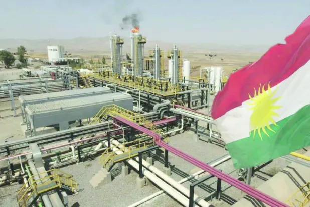 عَلم كردستان العراق أمام حقل نفط في الإقليم (رويترز)