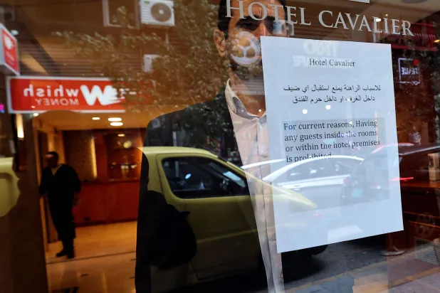 إشعار مطبوع ملصق بالقرب من نافذة أحد الفنادق يُعلم النزلاء بأنه ممنوع عليهم زيارة الفندق بسبب حالة الحرب في بيروت... 16 مارس 2026 (أ.ف.ب)