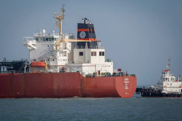 قارب تابع لخفر السواحل يقترب من ناقلة الغاز المسال الهندية «شيفاليك» لدى وصولها إلى ميناء موندرا عبر مضيق هرمز... الهند في 16 مارس 2026 (رويترز)