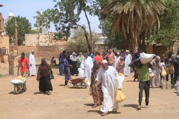 سودانيون يتلقون مساعدات غذائية من برنامج الأغذية العالمي في أم درمان يوم 11 مارس 2026 (أ.ف.ب)