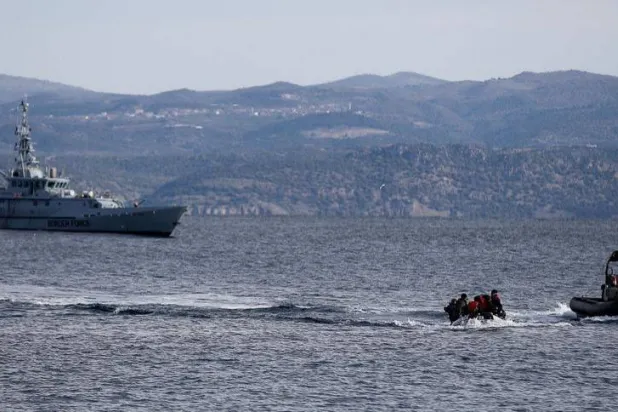 قارب إنقاذ يرافق قارباً صغيراً يحمل مهاجرين بينما تقوم سفينة تابعة لوكالة حرس الحدود الأوروبية «فرونتكس» بدورية في الخلفية قبالة جزيرة ليسبوس اليونانية (رويترز - أرشيفية)