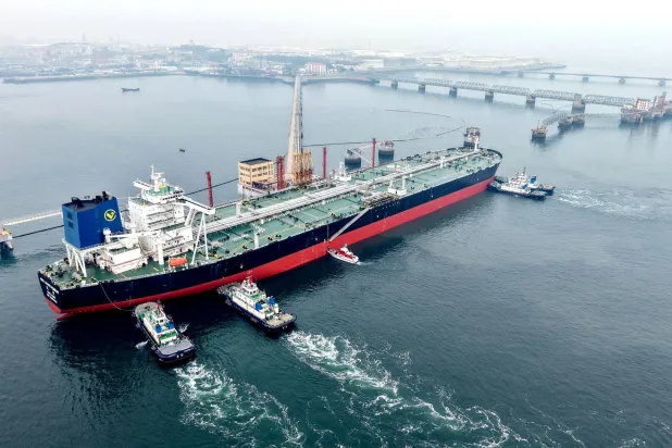 تُوجَّه ناقلة نفط إلى رصيفها في ميناء تشينغداو بمقاطعة شاندونغ شرق الصين (أ.ف.ب)