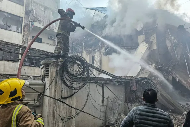 رجال الإطفاء يحاولون إخماد الحريق الذي اندلع في موقع غارة جوية إسرائيلية استهدفت ضاحية بيروت الجنوبية في الكفاءات (أ.ف.ب)