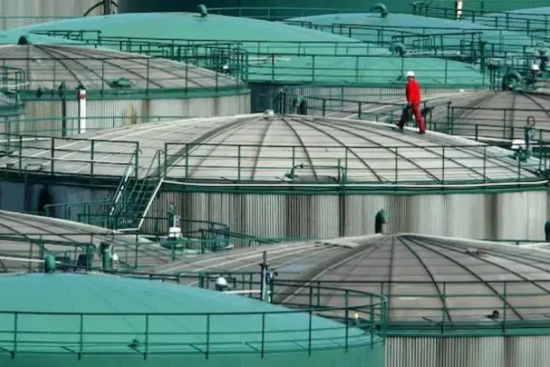 عامل يأخذ عينة من خزان نفط في منشأة لتخزين الوقود في مدينة هامبورغ شمال ألمانيا (رويترز)