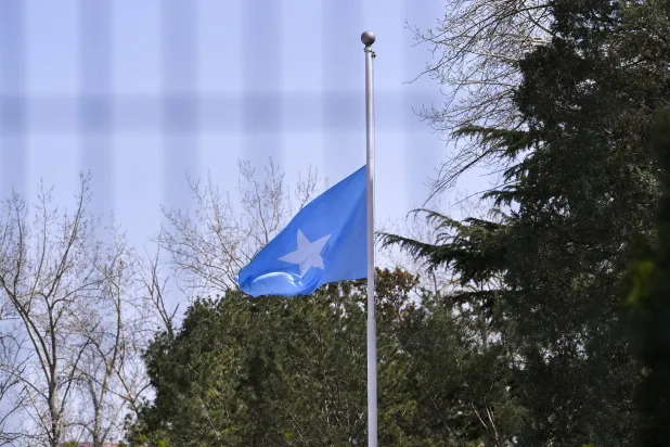 عَلَم الصومال منكساً حداداً على وفيات جائحة كورونا في سفارة الصومال ببكين 4 أبريل 2020 (رويترز)