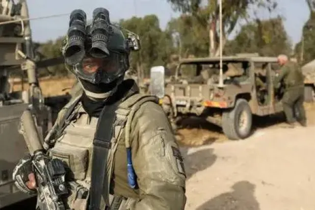 جندي إسرائيلي يقف بجوار مركبات عسكرية بالقرب من حدود إسرائيل مع قطاع غزة 1 مايو 2024 (رويترز)