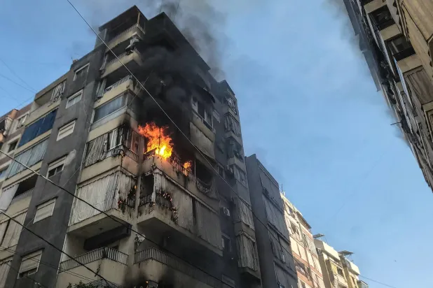 تتصاعد ألسنة اللهب من شقة استُهدفت بغارة جوية إسرائيلية في حي زقاق البلاط بوسط بيروت اليوم (أ.ف.ب)