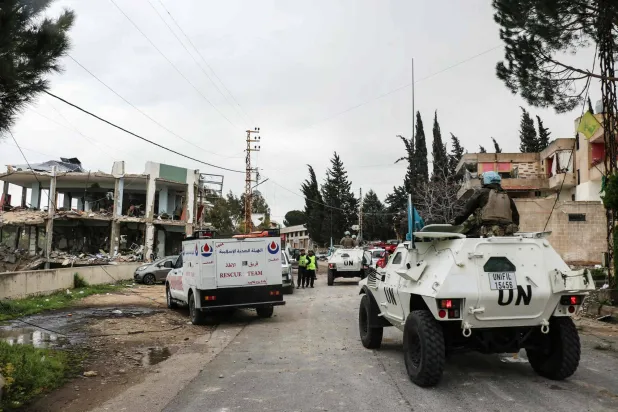 United Nations peacekeepers with the UN Interim Force in Lebanon (UNIFIL) drive past a destroyed healthcare center building in the aftermath of an Israeli strike in the southern Lebanese town of Burj Qalawiya on March 14, 2026. (AFP)