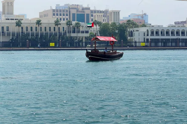 A man on a boat with an UAE flag near Dubai Creek, in Dubai, United Arab Emirates, March 5, 2026. Picture taken with a mobile phone. REUTERS/Rula Rouhana
