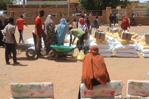 Residents receive aid from World Food Programme (WFP) at Al-Omada neighborhood of Omdurman, the twin city of Khartoum on March 11, 2026. (Photo by Ebrahim Hamid / AFP)
