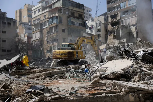 حفارة تزيل الأنقاض من موقع غارة إسرائيلية في حي زقاق البلاط بوسط بيروت في أعقاب تصعيد بين «حزب الله» وإسرائيل (رويترز)