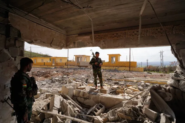 FILED - 11 March 2026, Iraq, Erbil: PAK Peshmerga members stand inside a family home destroyed by strikes at the PAKShar camp in Erbil's Ashkawt Saqa district. Photo: Ismael Adnan/dpa