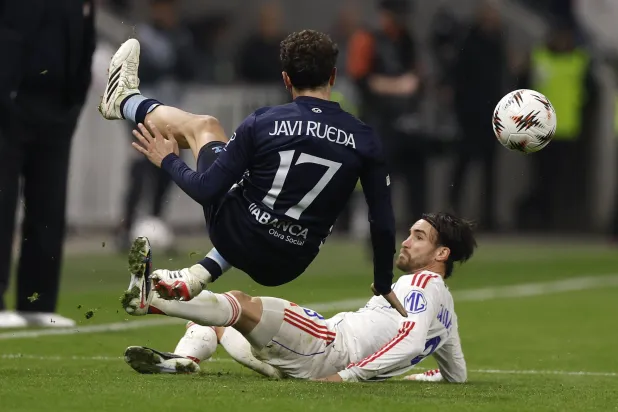 رويدا لاعب سيلتا فيغو يتعرض لدخول خشن من لاعب ليون نيكولا (إ.ب.أ)