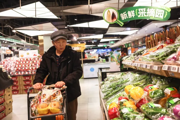 امرأة مسنة تتسوق داخل متجر في بكين (إ.ب.أ)