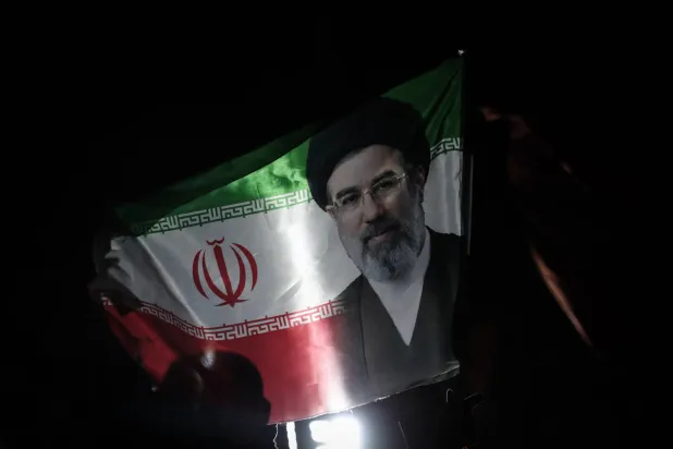19 March 2026, Iran, Tehran: An Iranian flag bearing the picture of 
Supreme Leader Mojtaba Khamenei, is waved in Tehran. Photo: Saeid Zareian/dpa
