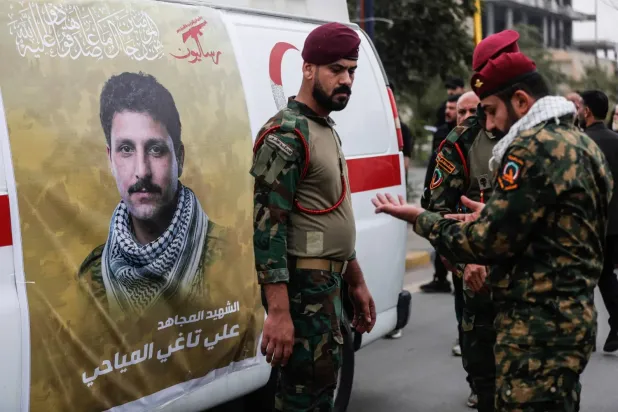 Irak Haşdi Şabi Güçleri, Salahaddin'e düzenlenen hava saldırısında öldürülen üyelerinden birinin fotoğrafının bulunduğu ambulansın yanında (AFP)