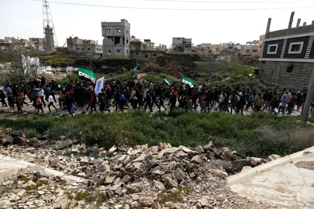  Demonstrators march during a rally commemorating the15th anniversary of the Syrian uprising against the Bashar al-Assad regime in Daraa, southern Syria, Wednesday, March 18, 2026. (AP) 