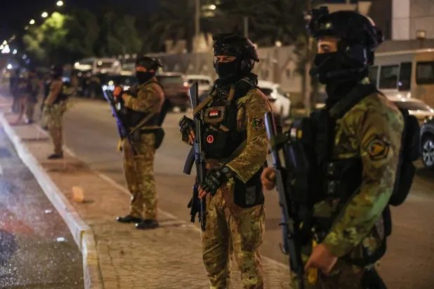  Security personnel stand guard during a funeral procession for members of Iraq's PMF, who were killed in an attack in al-Qaim province near the Syria border the previous evening, in Baghdad on March 17, 2026. (AFP)